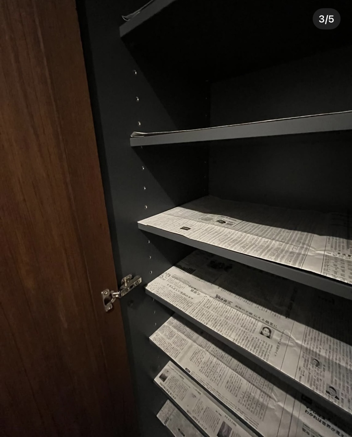 棚板に新聞紙を敷いている様子